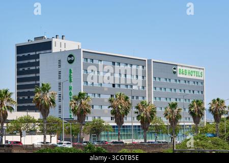 Viladecans. Barcelone - 29 août 2025 : la façade principale de l'Hôtel B B à Viladecans, entourée de palmiers et sous un ciel d'été clair. Banque D'Images