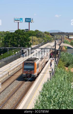 Viladecans. Barcelone - 29 août 2025 : les gens sur le quai de la gare, avec des panneaux d'affichage et l'infrastructure ferroviaire en arrière-plan, représentent Banque D'Images