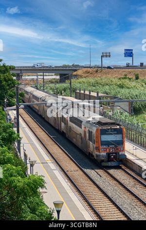 Viladecans. Barcelone - 29 août 2025 : L'écosystème des transports d'une ville moderne, montrant la coexistence du réseau ferroviaire et du trafic routier Banque D'Images