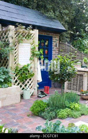 Un jardin vibrant rempli de divers légumes, outils de jardinage et un cabanon charmant, mettant en valeur un espace extérieur confortable. Banque D'Images