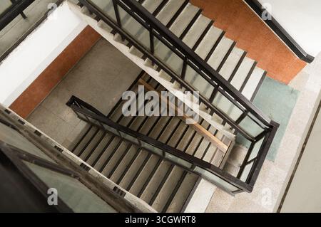 Perspective descendante d'escalier non gardé dans l'immeuble d'appartements. Banque D'Images