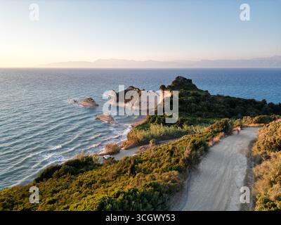 La vue imprenable sur le cap Drastis sur l'île de Corfou, avec l'Albanie en arrière-plan, pendant l'heure d'or. Banque D'Images