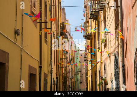 Bosa, Oristano, Sardaigne, Italie. Vue le long de la via Santa Croce dans le quartier historique de sa Costa, banderole colorée exposée. Banque D'Images
