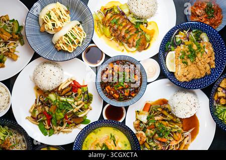 Plats asiatiques assortis avec riz, légumes et viande sur table, vue de dessus Banque D'Images