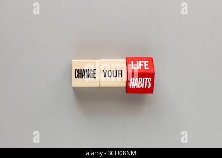 Concept DE VIE et D'HABITUDES. Une lettre sur des blocs de bois change le mot change Your Life and habits, beau fond gris. pose à plat, espace de copie Banque D'Images