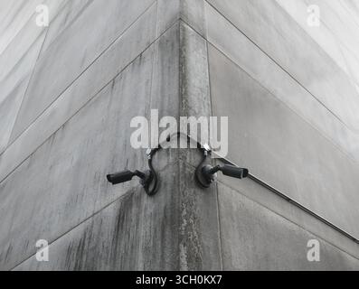 Deux caméras de sécurité noires montées sur le coin d'Un bâtiment en béton pour la surveillance et la surveillance urbaines Banque D'Images