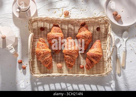 Croissants chauds et dorés aux noix françaises pour le petit déjeuner sucré. Petit déjeuner avec café et croissants. Banque D'Images