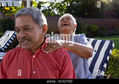 Couple de personnes âgées appréciant la relaxation en plein air, femme donnant un massage de l'épaule homme Banque D'Images