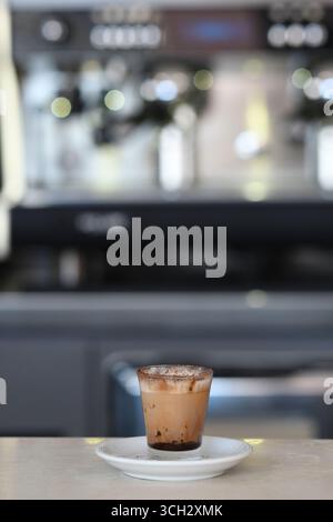 Cremona, Italie - 21 juillet 2025 délicieuse boisson au café glacé avec crème et sirop de chocolat servi dans une tasse en verre sur une soucoupe dans un cadre de café Lire Banque D'Images