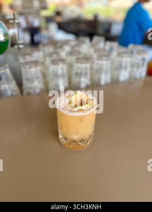cocktail icoholic avec vodka, jus d'ananas, mangue, liqueur, glace. Longue boisson ou mocktail froid d'été. Fond sombre tropical avec des feuilles de palmier et e Banque D'Images