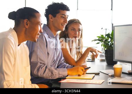 Équipe commerciale collaborant au bureau, analysant les données sur l'écran de l'ordinateur Banque D'Images