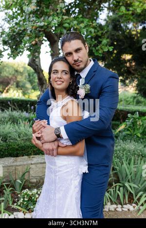 Mariée et mariée embrassant dans le jardin, célébrant l'amour le jour du mariage Banque D'Images