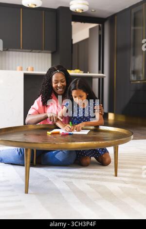 Heureuse mère et fille dessinant à la maison, profitant du temps créatif Banque D'Images