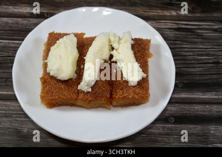 Basbosa au lait crémeux laitier qeshta crémeux coagulé et saturé de sirop sucré de miel, Basbusa est un dessert du moyen-Orient qui est généralement du bak Banque D'Images