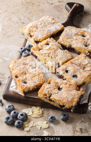 Gâteau doux et humide aux myrtilles amandes gros plan sur la planche de bois sur la table. Vertical Banque D'Images