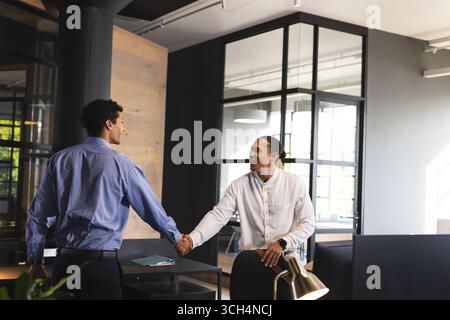 Professionnels se serrant la main dans un bureau moderne, scellant l'affaire réussie Banque D'Images