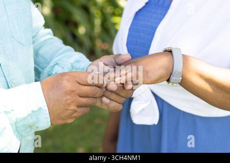 Couple senior échangeant des anneaux à l'extérieur, célébrant l'amour et l'engagement ensemble Banque D'Images