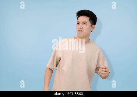 jeune homme surpris exprimant le choc sur un fond bleu vif Banque D'Images