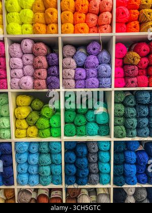 boules de laine multicolores dans un magasin, disposées à l'ombre. Banque D'Images