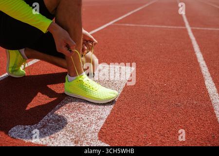 Homme attachant chaussures de course, sport et Jeux Olympiques. Banque D'Images