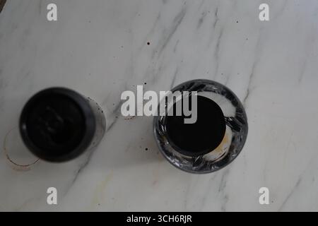 Une photo au-dessus de deux bouchons de bouteille, l'un fermé et l'autre avec un intérieur noir, affichés sur une surface en marbre texturé, mettant en évidence les détails et Banque D'Images