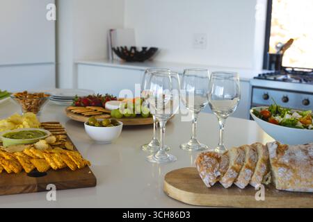 Table élégante avec verres à vin, pain frais et hors-d'œuvre variés Banque D'Images