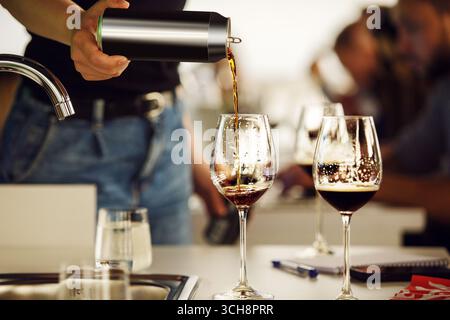 Gros plan photo de verser de la bière Stout de la canette aux verres Banque D'Images