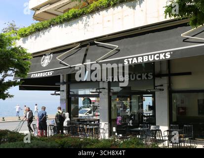 Thessalonique, Grèce-23 avril 2025 : personnes non identifiées pêchant, debout et assis près du Starbucks Coffeehouse au bord de la mer Égée Banque D'Images