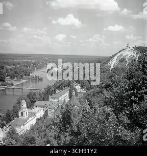 Une magnifique vue panoramique de Sviatohirsk, prise depuis une falaise de craie dans les années 1970-80 Le plan montre le célèbre ensemble architectural des montagnes saintes Lavra (alors un sanatorium), la rivière Seversky Donets, un pont et une plage publique bondée. Il s'agit d'une image de carte postale classique de la principale station balnéaire de Donbass, célèbre pour sa nature unique. La photographie est un symbole puissant et nostalgique de l'harmonie, de la beauté et d'une vie paisible et insouciante avant la guerre Banque D'Images