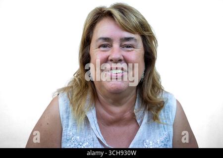 Portrait en gros plan d'une femme mature joyeuse aux cheveux blonds souriant naturellement. Concept de bonheur, de confiance, de beauté naturelle et de vie authentique Banque D'Images