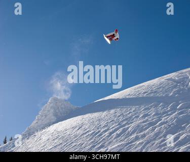 Snowboarder qui tourne après un saut dans l'arrière-pays du Colorado. Banque D'Images