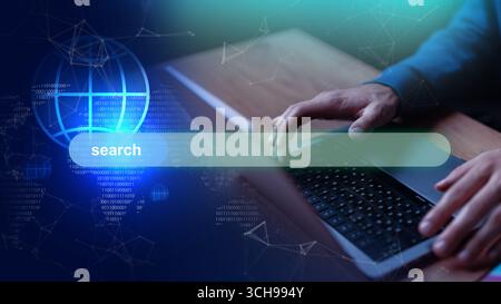 Utilisateur tapant sur un ordinateur portable avec une interface numérique affichant une barre de recherche et la visualisation des données Banque D'Images