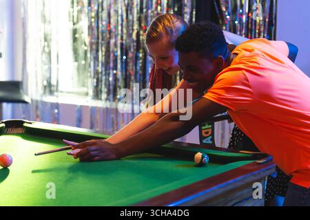 Adolescents divers amis jouant au billard ensemble, souriant et profitant du temps à la fête, à la maison. Billard, loisirs, amitié, divertissement, jeunesse, cele Banque D'Images