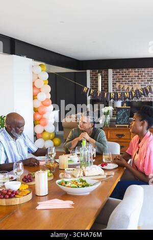 Célébrer la retraite, famille adulte souper et partager la conversation à la maison. célébration, temps adulte en famille, ensemble, bonheur, lien Banque D'Images