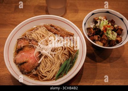 Bol de ramen japonais avec tranches de porc et oignons verts servi avec un bol de riz avec de la viande grillée à Kyoto, Japon. Banque D'Images