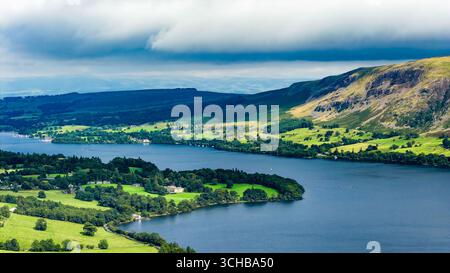 Des nuages spectaculaires projetant des ombres sur le paysage paisible d'Ullswater en été Banque D'Images