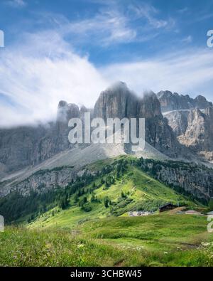 Paysage matinal spectaculaire à Passo Gardena avec des prairies verdoyantes entourées de majestueux sommets des Dolomites couverts de nuages, région du Tyrol du Sud, Italie Banque D'Images