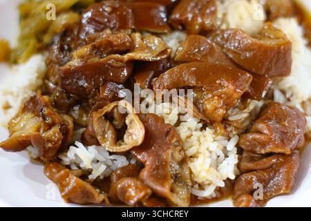 Intestins de porc ragoûtés dans une sauce brune avec riz, plat traditionnel thaïlandais de Street food, mettant en valeur les saveurs de l'Asie du Sud-est et la cuisine locale. Banque D'Images