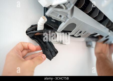 Défaillance de l'isolation CA sur le tuyau du climatiseur provoquant une fuite d'eau le long du mur de l'appartement Banque D'Images