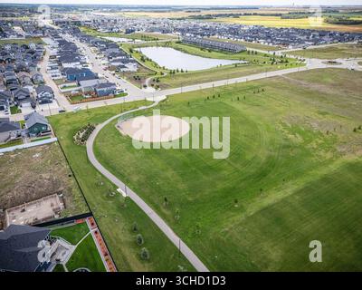 Vue aérienne de Kensington à Saskatoon, Saskatchewan, montrant les nouvelles maisons, étangs et parcs communautaires. Banque D'Images