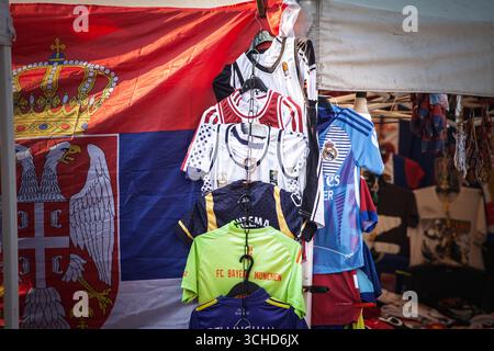 OBRENOVAC, SERBIE - 2 AOÛT 2025 : assortiment de maillots de football européens accrochés à la vente sur un stand de marché à Obrenovac, aux couleurs du club, Real Madrid, FC B. Banque D'Images