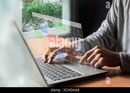 Calendrier pour les rendez-vous mensuels et la planification, gestion de son horaire d'affaires, main marquant les dates sur le calendrier virtuel Banque D'Images