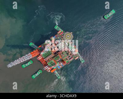 L'usine flottante de production de gaz naturel à grande échelle, Scarabeo 5, construite par une compagnie maritime chinoise pour une compagnie italienne, a quitté la base de construction CIMC Raffles à Yantai, Shandong, Chine, le 1er septembre 2025, sous le remorquage d'un remorqueur. Banque D'Images