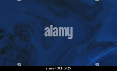 Taches d'encre. Flux de mélange. Le marbre d'eau brillante de couleur bleue défocalisée éclaire la texture chimique se déplaçant sur fond noir foncé d'art abstrait. Banque D'Images