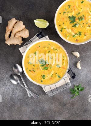 Soupe traditionnelle indienne Mulligatawny avec lentilles et poulet sur fond sombre. Vue de dessus. Banque D'Images