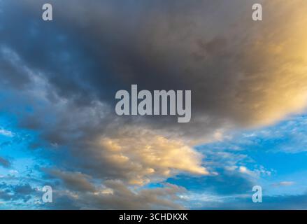 Nuage d'orage sombre avec une lumière dorée au-dessus du ciel bleu Banque D'Images