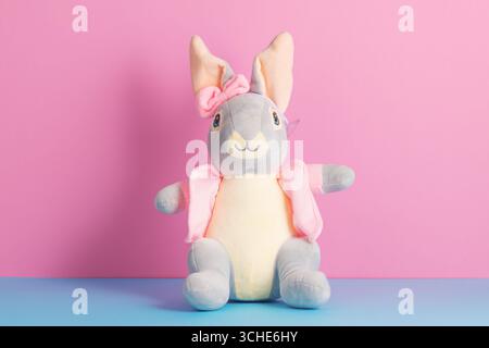 Jouet de lapin de Pâques en peluche mignon sur un fond coloré lumineux Banque D'Images