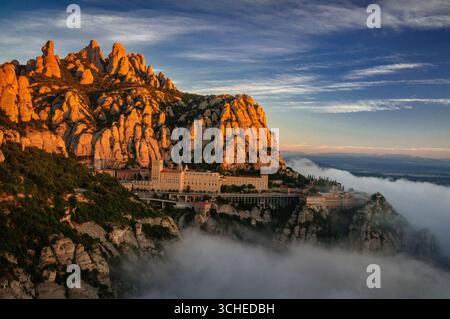 Montserrat et l'abbaye de Montserrat au lever du soleil avec une mer de nuages vus du point de vue du Creu de Sant Miquel (province de Barcelone, Catalogne, Espagne) Banque D'Images