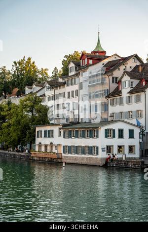 Vue panoramique et calme sur Zurich et la rivière Limmat au coucher du soleil vu de Limmatquai à Zurich, Suisse. Banque D'Images