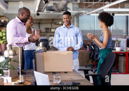 Célébrer ensemble, divers collègues souriant et applaudissant dans un bureau moderne Banque D'Images